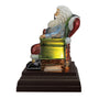 Side view of Santa seated beside the fireplace on a tiered black base
