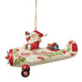 Jim Shore ornament featuring Santa waving from a cream and red airplane with holly accents, gifts in the back, and Merry Christmas written on the side. Side View. 