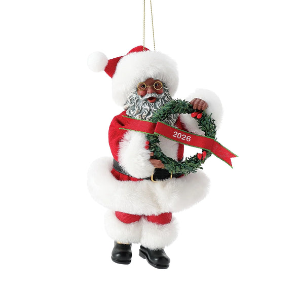 Front view of 2026 Dated Possible Dreams Clothtique Santa Ornament featuring an African American Santa in a faux fur trimmed suit holding a wreath with 2026 ribbon.
