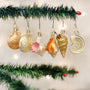 Decorative Seashell Christmas ornaments hanging on a tree branch with a blurred background