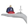 Glass ornament shaped like a baseball cap with a measurement on a hand