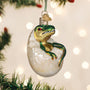 Baby Dinosaur Christmas ornament in a cracked egg on a decorated tree with lights.