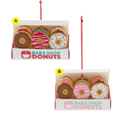 Red Assortment: Ornament shaped like an open donut box with three decorated donuts and a Bake Shop Donuts label in red and teal.
Pink Assortment: Ornament shaped like an open donut box with three decorated donuts and a Bake Shop Donuts label in pink and green.
