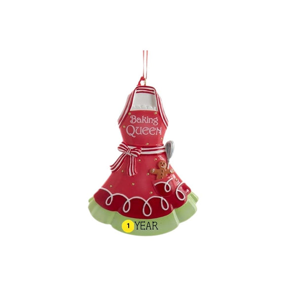 Baking Queen apron ornament in red with a gingerbread cookie, baking spoon, striped bow, festive holiday details, and sample year personalization.