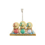 Decorative ornament with three figures wearing beach hats and swimsuits, hanging on a white background.