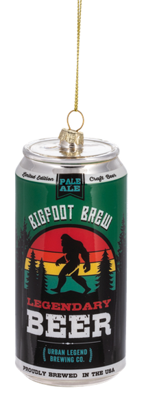 Glass ornament shaped like a beer can labeled “Bigfoot Brew Legendary Beer,” featuring a Bigfoot silhouette with a colorful sunset stripe design.