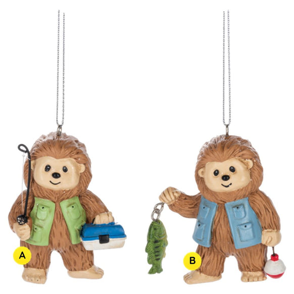 Bigfoot fishing ornaments featuring two smiling Sasquatch figures in fishing vests, one holding a rod and tackle box and the other holding a fish and bobber.