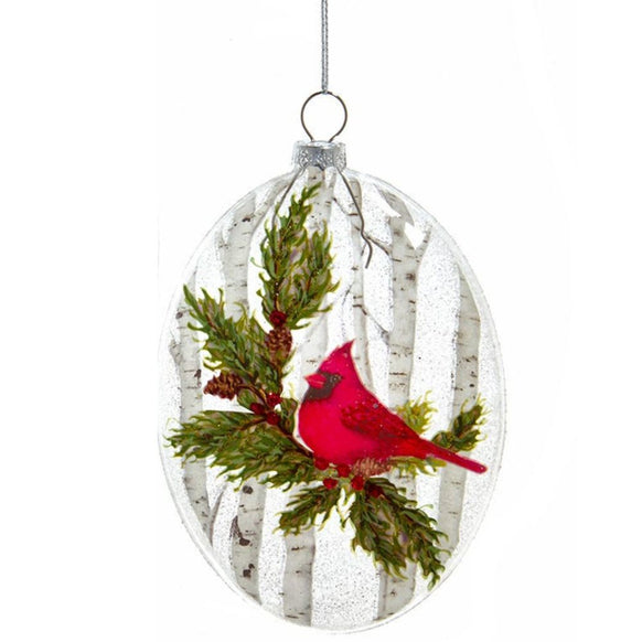 Glass disc ornament featuring a single red cardinal perched among evergreen branches with white birch trees in the background.