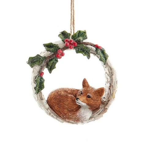 Birch-style wreath ornament with holly leaves and red berries, featuring a curled fox resting inside the ring.