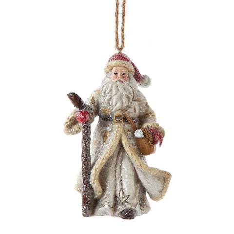 Santa ornament in a textured winter coat with snowy detail, holding a walking staff and brown satchel in a rustic woodland style.