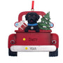Christmas ornament of a black lab dog in a red truck with a tree and presents.