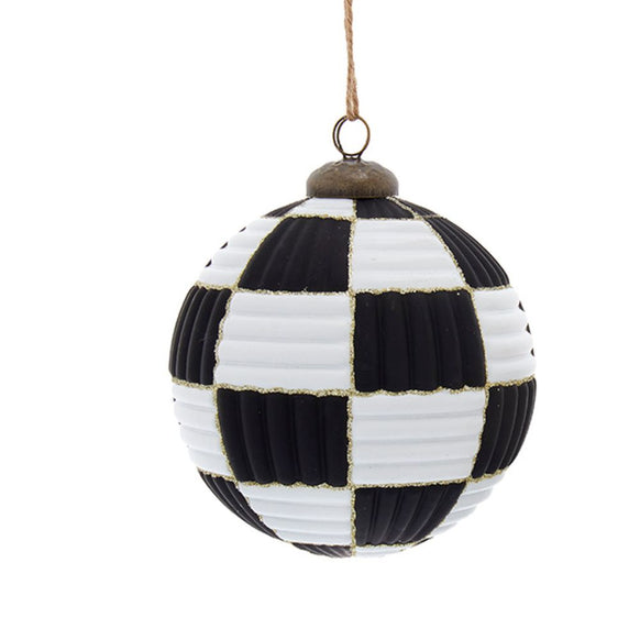 Black and white patchwork ball ornament with ribbed panels, gold glitter trim, dark cap, and jute hanging cord.