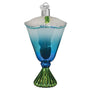 Decorative glass ornament resembling a cocktail with blue liquid, green base, and white foam on a white background.
