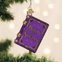 Decorative ornament shaped like a 'Book of Spells' hanging on a Christmas tree.
