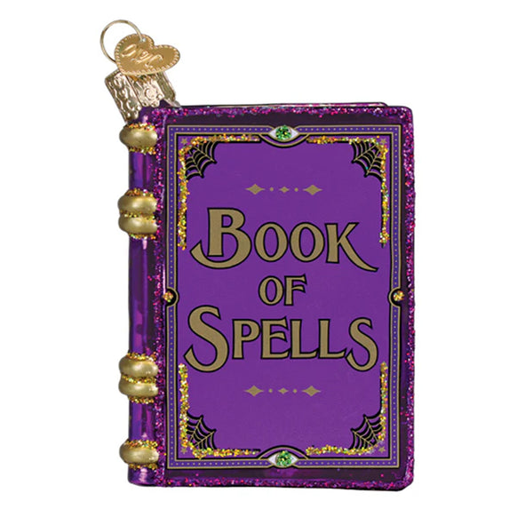 Decorative ornament shaped like a 'Book of Spells' with purple cover and gold accents on a white background.