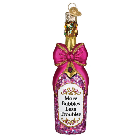 Decorative bottle ornament with pink glitter, gold bow, and 'More Bubbles Less Troubles' text on a white background.