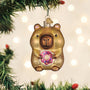 Capybara ornament holding a pink donut with sprinkles on a white background on a tree