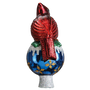 Back view of a red cardinal tree topper sitting on a blue ornament-shaped base with white glittered snow accents and gold details.