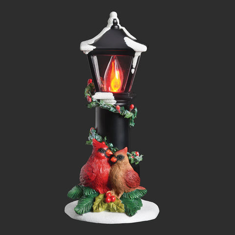 Cardinals Nestled Under a Flickering Flame Lamppost Night-Light with two birds resting beneath a snowy black lamppost wrapped in holly and berries