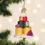 Decorative cheese tower ornament on a Christmas tree with lights in the background