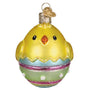 Glass ornament shaped like a chick in an egg with a white background