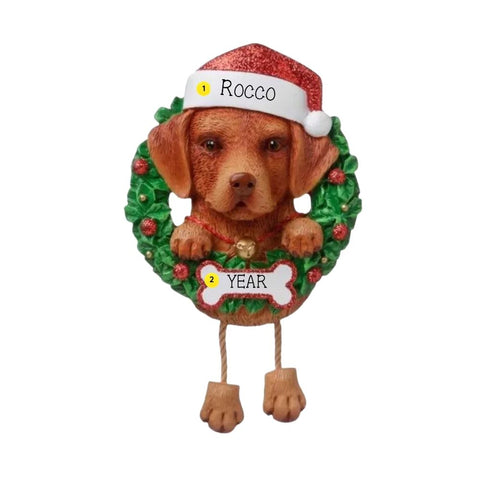 Personalized chocolate Lab ornament with a brown Labrador in a Santa hat peeking through a green wreath with space for a name and year.