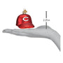 Red glass ornament shaped like a Cincinnati Reds baseball cap with a measurement on a hand