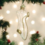 Glass ornament shaped like Cinderella's Slipper gold detailing, hanging on a Christmas tree with lights in the background.