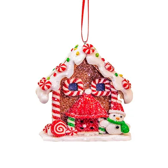 Decorative gingerbread house ornament with candy details on a white background