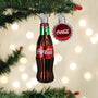 Coca-Cola bottle and bottle cap ornament on a Christmas tree with lights in the background