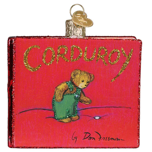 Decorative ornament shaped like a book titled 'Corduroy' with a teddy bear illustration on a red background.
