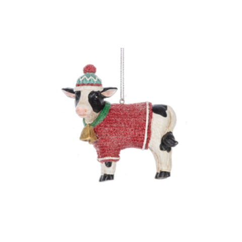 Cow in Cozy Sweater ornament featuring a black-and-white cow wearing a red sweater, green scarf, and colorful winter hat.