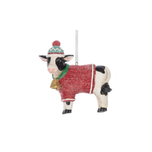 Cow in Cozy Sweater ornament featuring a black-and-white cow wearing a red sweater, green scarf, and colorful winter hat.