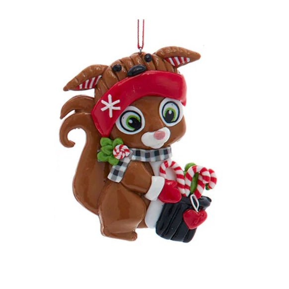 Claydough squirrel ornament wearing a red winter hat and plaid scarf while holding candy canes and a small black bag.