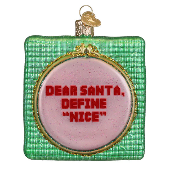 Cross Stitched glass ornament with a sassy saying Dear Santa define "Nice" on white background