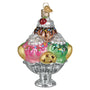 Decorative glass ice cream sundae ornament with various treats on a white background