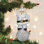 Decorative Christmas ornament of a glass Santa Claus figure on a tree with lights in the background