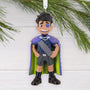 Elio Character Ornament with a blue cape and green accents on a white background