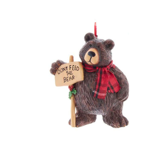 Brown bear ornament wearing a red plaid scarf and holding a sign that reads “Don’t Feed the Bear.”