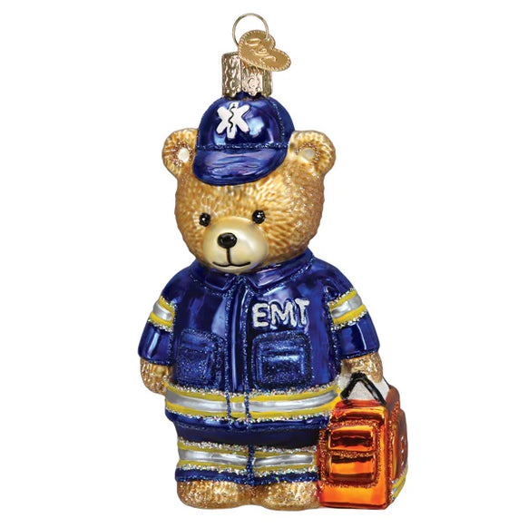 Glass ornament of a teddy bear wearing an EMT uniform and hat on a white background