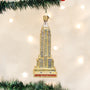 Christmas ornament of the Empire State Building on a tree with lights in the background