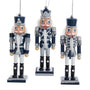 Three nutcracker ornaments in blue, silver, and white on a white background