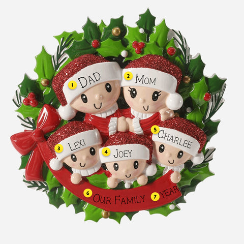 Christmas ornament with 5 family figures and holly leaves on a white background