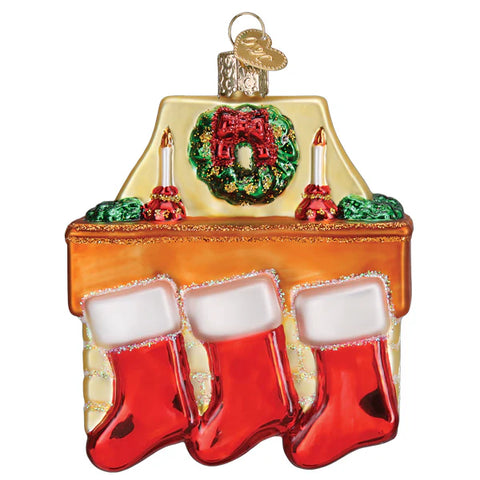 Decorative Christmas ornament shaped like a fireplace with stockings, wreath, and candles.