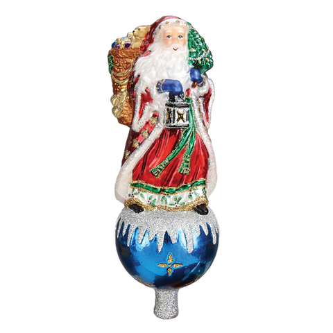 Father Christmas tree topper in a red robe holding a lantern and small tree, standing on a blue ornament-style base with snowy accents.