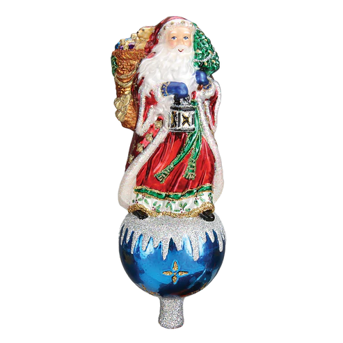 Father Christmas tree topper in a red robe holding a lantern and small tree, standing on a blue ornament-style base with snowy accents.