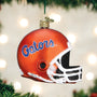 Glass football helmet ornament with 'Gators' text on a Christmas tree.