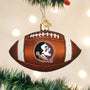 Glass football ornament with logo Florida State hanging on a Christmas tree