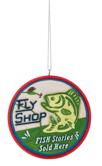 Round fishing ornament with a red border, featuring a green jumping fish, a fishing fly, and the words “Fly Shop” and “Fish Stories Sold Here.”
