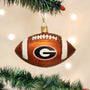 Glass football ornament with Georgia  logo hanging on a Christmas tree.